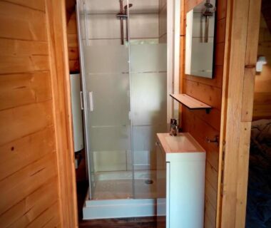 Salle d'eau avec cabine de douche dans un chalet en bois au Camping Domaine de Mepillat