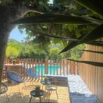 Terrasse en bois avec piscine et fauteuils au Camping Domaine de la GAUTIERE