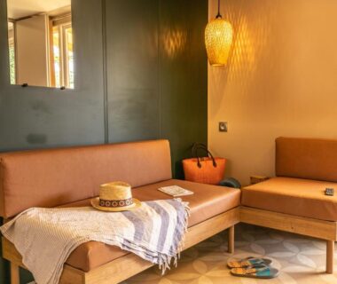 Intérieur coin salon avec banquette et lampe au Camping Domaine de la Ville Huchet