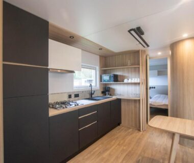 Cuisine équipée et coin repas dans le mobil-home du Camping Domaine de la Ville Huchet