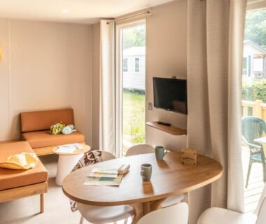 Intérieur salon et terrasse d'un mobil-home au Camping Domaine de la Ville Huchet