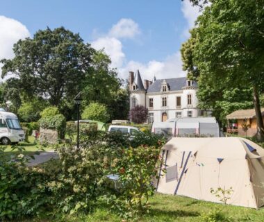 Emplacement de tente et caravanes dans un parc arboré au Camping Domaine de la Ville Huchet