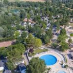 Vue aérienne avec piscine ronde et mobil-homes au Camping Domaine des Iscles