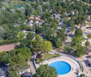Vue aérienne avec piscine ronde et mobil-homes au Camping Domaine des Iscles