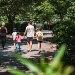 Allée ombragée avec famille marchant au Camping Domaine du Cros d'Auzon - Maeva