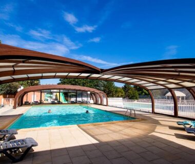 Piscine couverte avec voûtes en bois au Camping Domaine du Cros d'Auzon Maeva