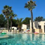 Piscine extérieure avec palmiers et transats au Camping Domaine du Golfe de St Tropez Aquatique Vacances