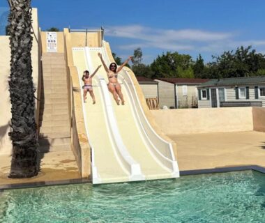 Piscine avec toboggans et palmiers au Camping Domaine du Golfe de St Tropez - Aquatique Vacances