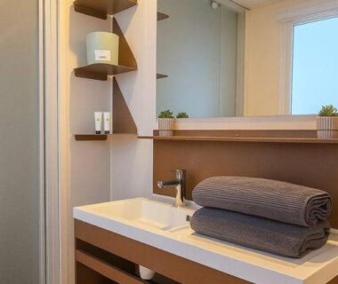 Salle de bain avec lavabo miroir et serviettes dans le mobile-home pour 6 personnes du Camping Domaine la Yole