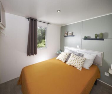 Chambre double avec lit et fenêtre au Camping Domaine le Quercy