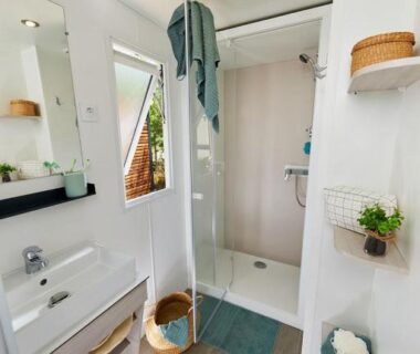 Salle de bain avec douche et lavabo au Camping Domaine le Quercy