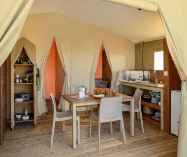 Intérieur de tente avec coin repas et kitchenette au Camping Domaine le Quercy