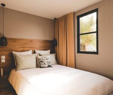 Chambre avec lit double et fenêtre au Camping Domaine le Quercy