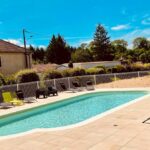 Piscine extérieure entourée de transats au camping Du Paquier Fané