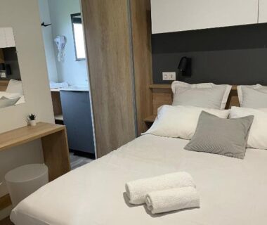 Intérieur de mobil-home avec lit double et serviettes au Camping Du Perche Bellemois