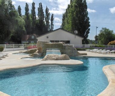 Piscine extérieure avec cascade et transats au Camping Du Port De Plaisance