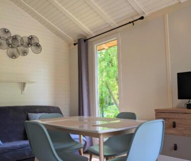 Séjour avec table et canapé dans le mobil-home du Camping Du Port De Plaisance