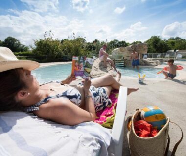 Bord de piscine avec transat et enfants au Camping Du Port De Plaisance