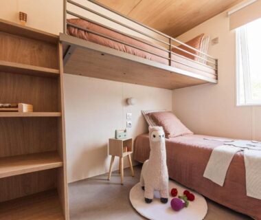 Chambre avec lits superposés, lit simple et peluche près de la fenêtre au Camping Dun-le-Palestel