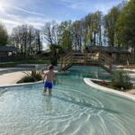Piscine extérieure avec enfant et passerelle au camping Dun-le-Palestel