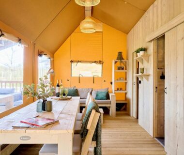 Intérieur de lodge en bois avec table et coin salon du Camping Dun-le-Palestel