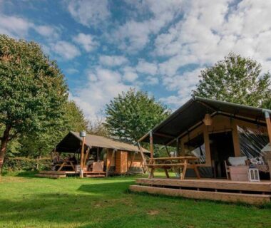 Prairie avec lodges en bois et terrasses au Camping Dun-le-Palestel
