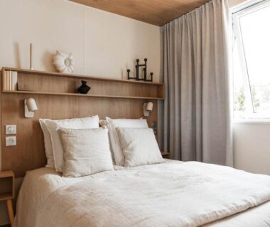 Chambre double lumineuse avec lit et fenêtre au Camping Dun-le-Palestel