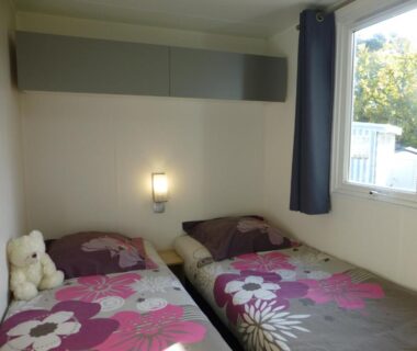 Chambre avec deux lits simples et peluche dans le mobil-home du Camping Eden