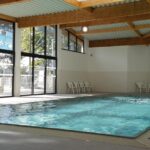 Piscine intérieure avec grandes baies vitrées au Camping Eden