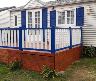 Terrasse et façade de mobil-home avec volets bleus au Camping Ernest Renan
