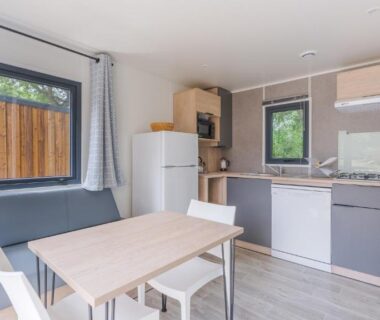 Séjour avec kitchenette et table à manger au Camping Etennemare