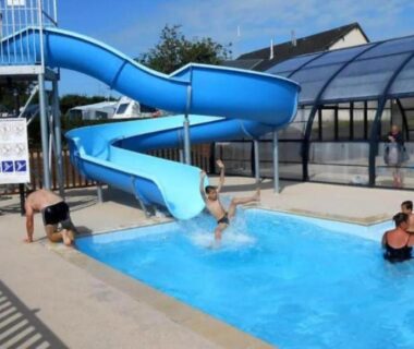Piscine extérieure avec toboggan et toit vitré au Camping Etennemare