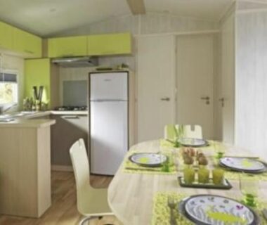 Intérieur séjour avec kitchenette et table dressée au Camping Etennemare