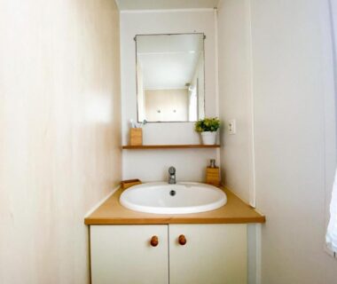 Salle d'eau avec lavabo et miroir au Camping Europcamping