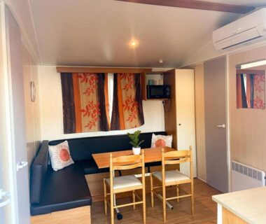 Intérieur du mobil home avec banquette et table à manger au Camping Europcamping