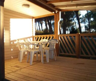 Terrasse couverte avec table et chaises blanches du Camping Figurotta