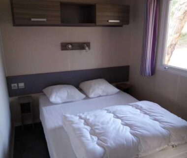 Chambre avec lit double et fenêtre au Camping Figurotta