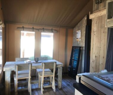 Intérieur de tente avec table et chaises au Camping Haliotis