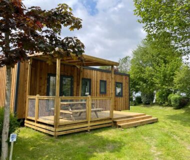Locatif en bois avec terrasse sur pelouse dans le Camping Haliotis