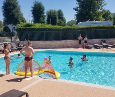 Piscine extérieure avec enfants et transats au Camping Haliotis