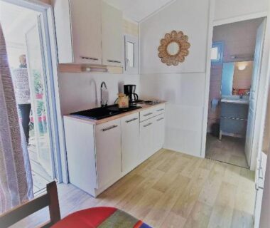 Coin cuisine et coin repas dans le mobil-home du camping Hameau Des Cannisses