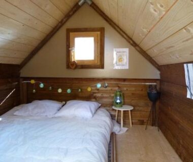 Chambre mansardée en bois avec lit au Camping Hello Soleil