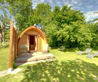 Pelouse avec cabane en bois et deux chaises longues du Camping-Hotel de Plein Air Les 2 Bois