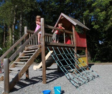 Aire de jeux en bois avec enfants au Camping-Hotel de Plein Air Les 2 Bois
