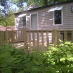 Terrasse en bois devant mobil-home dans la végétation au Camping Hurongues