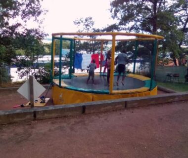 Aire de jeux trampoline couvert avec enfants au Camping Hurongues