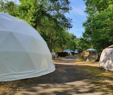 Allée de dômes et tentes sous les arbres du Camping Hurongues