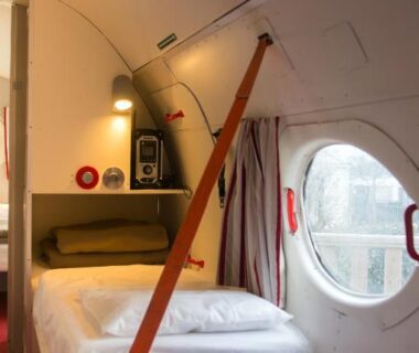 Intérieur de cabine avec lit et hublot dans le Camping Insolite Le Haut Village