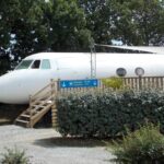 Fuselage d'avion aménagé dans la végétation au Camping Insolite Le Haut Village