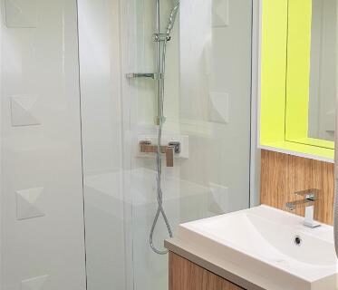 Salle de bains avec cabine de douche et lavabo au Camping Insolite Le Haut Village